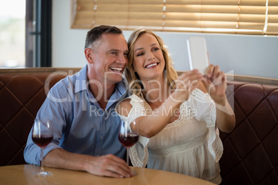 Couple taking selfie on mobile phone in restaurant