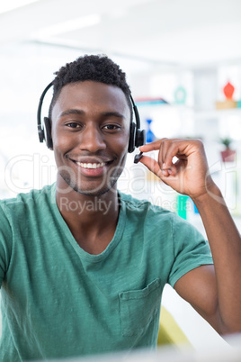 Male executive in headset at his desk in office