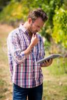 Young man using digital tablet at vineyard
