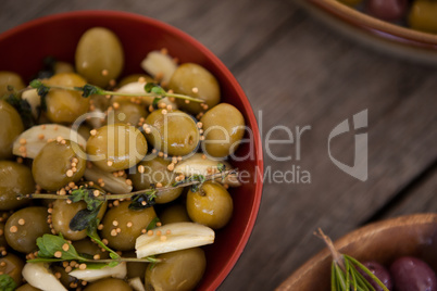 Close up of green olives with spice served in bowl