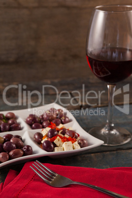 Black olives served in plate by wine on table