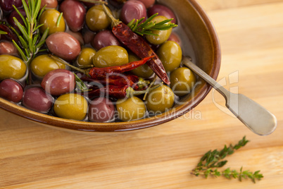 High angle view of olives with red chili pepper and herb