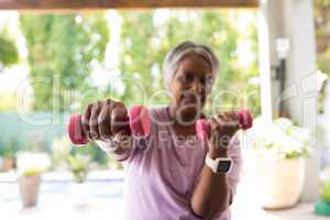 Portrait of senior woman exercising with dumbbell