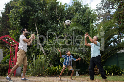 Family playing with soccer ball at park