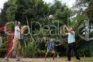 Family playing with soccer ball at park