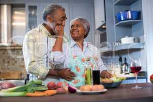 Affectionate senior couple preparing food