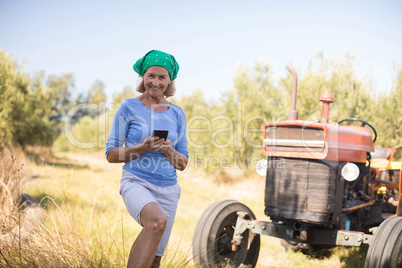 Portrait of happy woman using mobile phone in olive farm