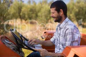 Man using laptop in tractor