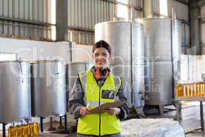 Portrait of female technician writing in clipboard