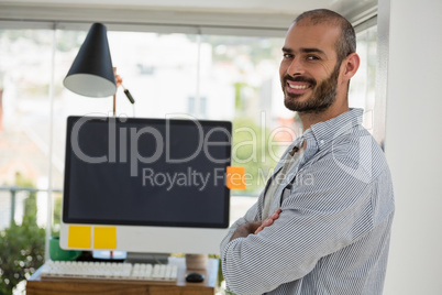 Portrait of designer with arms crossed standing in office