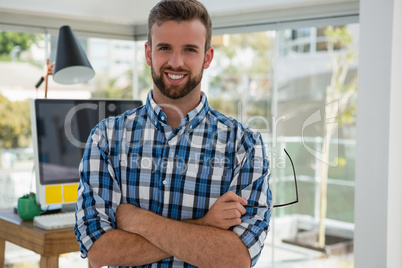 Portrait of smiling businessman standing in office