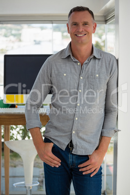 Portrait of confident businessman leaning on wall