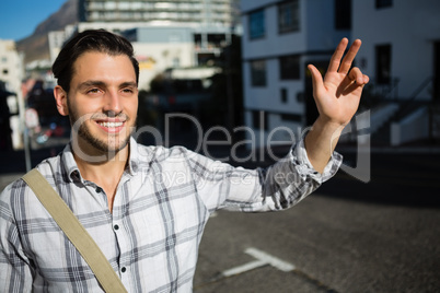 Smiling man gesturing while standing on city street