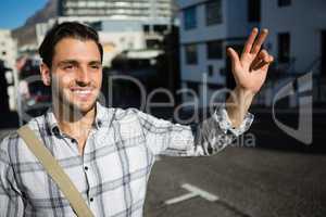 Smiling man gesturing while standing on city street