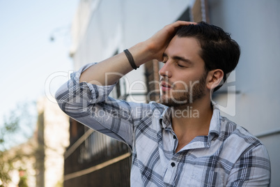 Tensed man sitting by wall