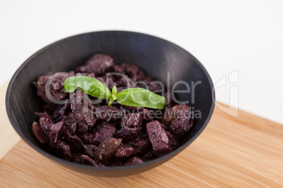 Close up of dried olives in bowl on cutting board