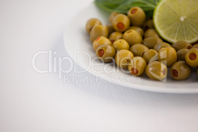 Cropped image of olives in plate with lemon