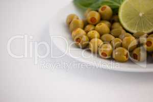 Cropped image of olives in plate with lemon
