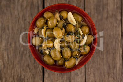 Directly above shot of olives with garlic and oil in bowl
