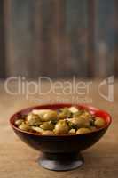 Close up of green olives in red bowl