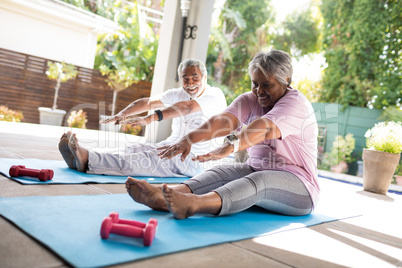 Full length of senior couple doing stretching exercise