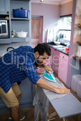 Full length of man ironing shirt