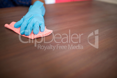 Cropped image of person cleaning table