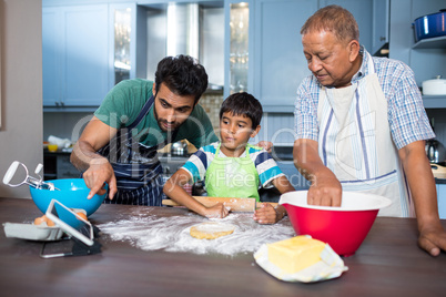 Man showing tablet to son while preparing food