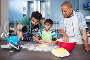 Man showing tablet to son while preparing food