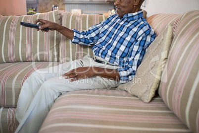 Midsection of man holding remote control