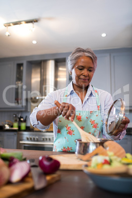 Senior woman making food in kitchen