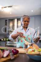 Senior woman making food in kitchen