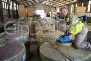 Portrait of happy worker removing oil from tank