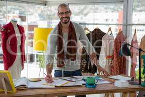 Portrait of smiling male designer drawing sketch at table