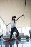 Low angle view of businesswoman wearing virtual reality simulator exercising