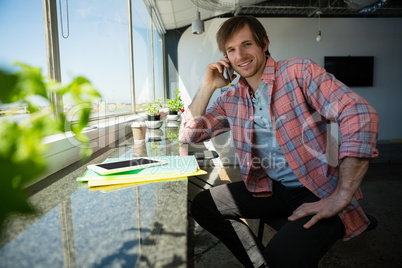 Portrait of smiling young businessman talking on phone