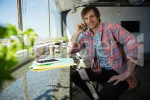 Portrait of smiling young businessman talking on phone