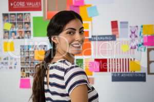 Portrait of smiling woman against sticky notes in office