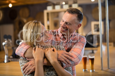 Man embracing woman from back in bar