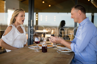 Man giving engagement ring to surprised woman