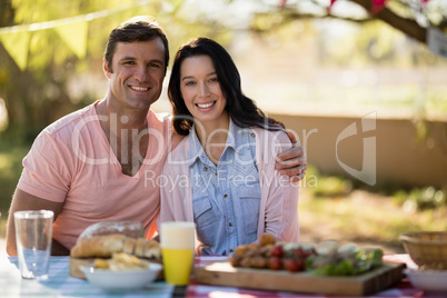 Couple sitting together with arm around in park