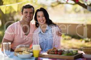 Couple sitting together with arm around in park