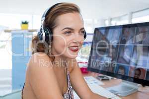 Female executive in headset at his desk in office