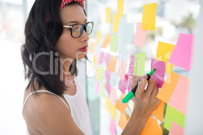 Female executive writing on sticky notes