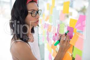 Female executive writing on sticky notes