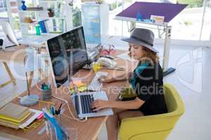 Female executive using laptop and computer