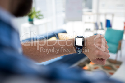 Male executive checking time on smartwatch