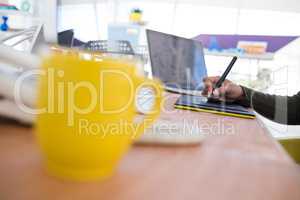 Female graphic designer using graphic tablet at desk