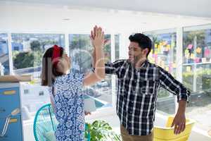 Couple giving high five to each other in the office