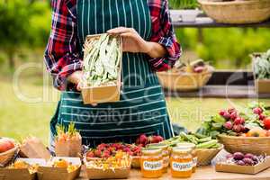 Midsection of young woman selling organic vegetables